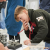 A young person crouches to inspect an engineering experiment apparatus more closely at the Sellafield careers day