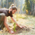 An apprentice in a green apprenticeship plants a tree in a forest